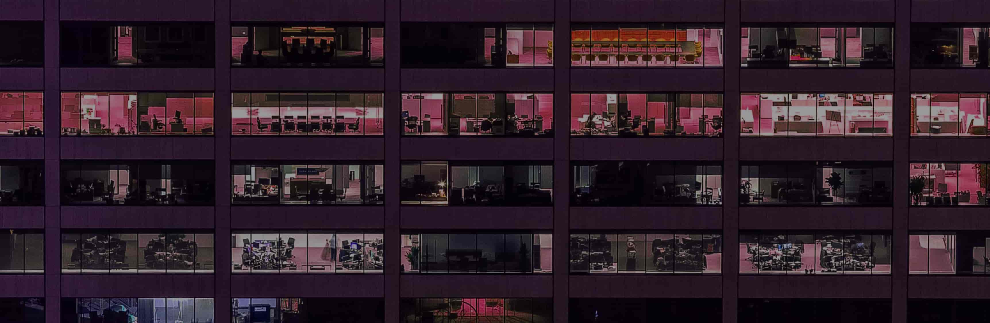 Vista frontal edificio oficinas iluminadas