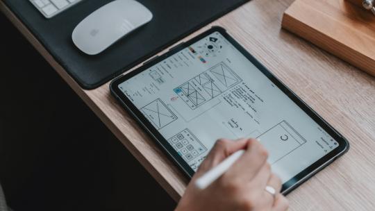 Persona diseñando en una tableta gráfica.