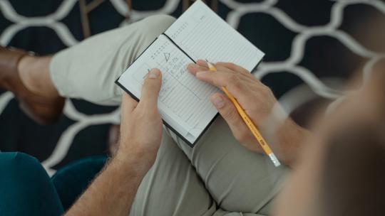 Persona tomando notas en un cuaderno.