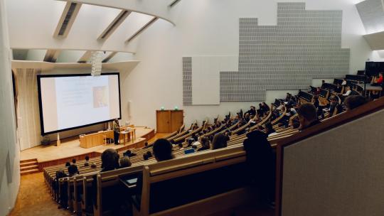 Aula magna repleta de alumnos.