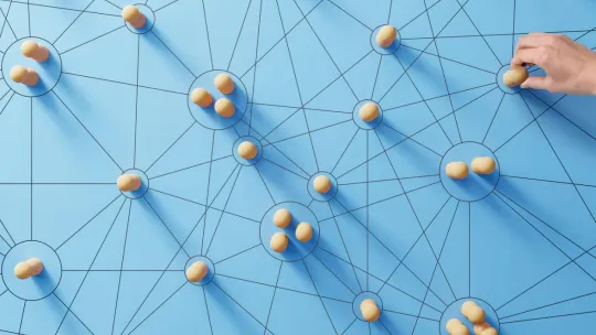 Red de nodos azules conectados con piezas de madera y una mano interactuando.