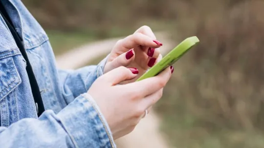 Manos de mujer utilizando un móvil