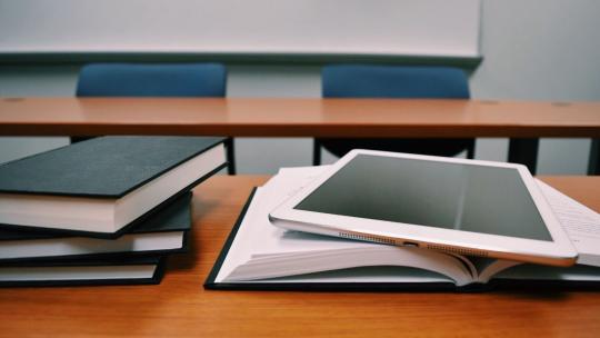 Mesa con libros y un iPad.