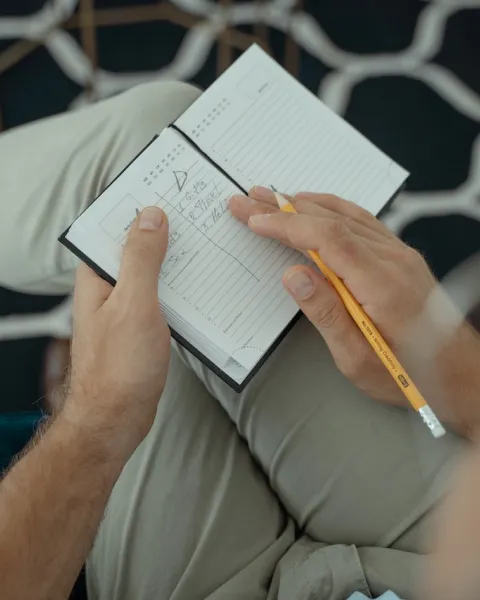 Persona tomando notas en un cuaderno.