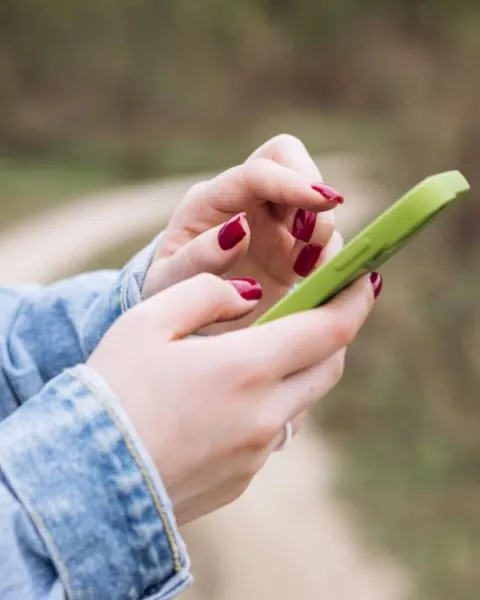 Manos de mujer utilizando un móvil