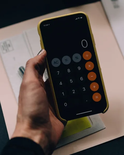 Persona sujetando una calculadora.