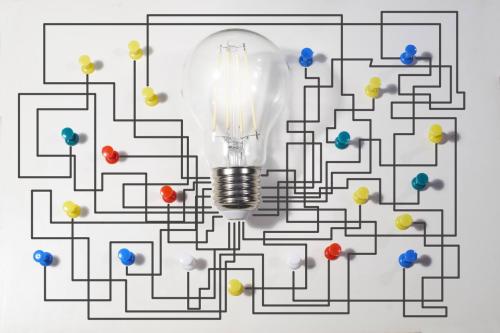 Bombilla con una pared de fondo y un mapa de chinchetas