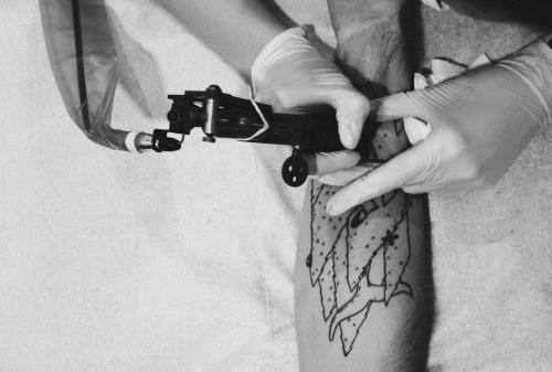 Persona tatuando un brazo.