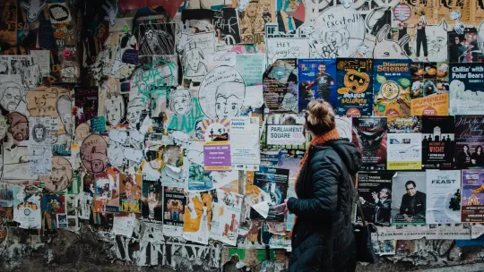 Persona viendo carteles en una pared