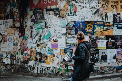 Persona viendo carteles en una pared